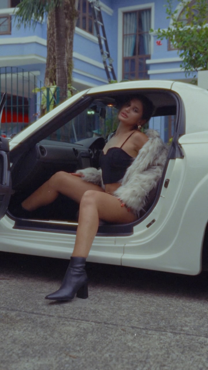 Ksenia beside a white sports car